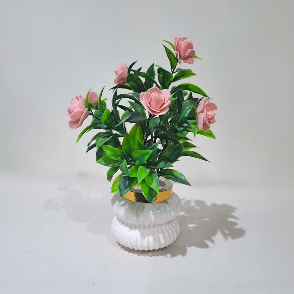 Peach Camellia-Style Blossoms and lush green foliage in a white, ribbed Plastic Pot