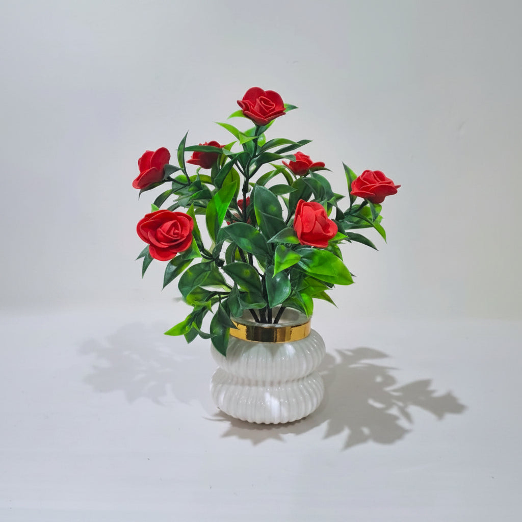 Red Camellia-Style Blossoms and lush green foliage in a white, ribbed Plastic Pot