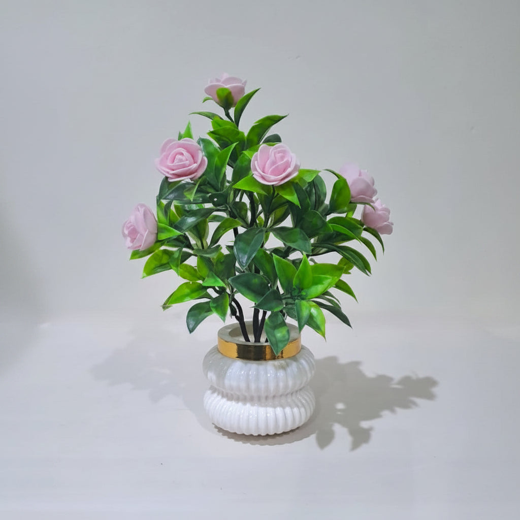 Pink Camellia-Style Blossoms and lush green foliage in a white, ribbed Plastic Pot
