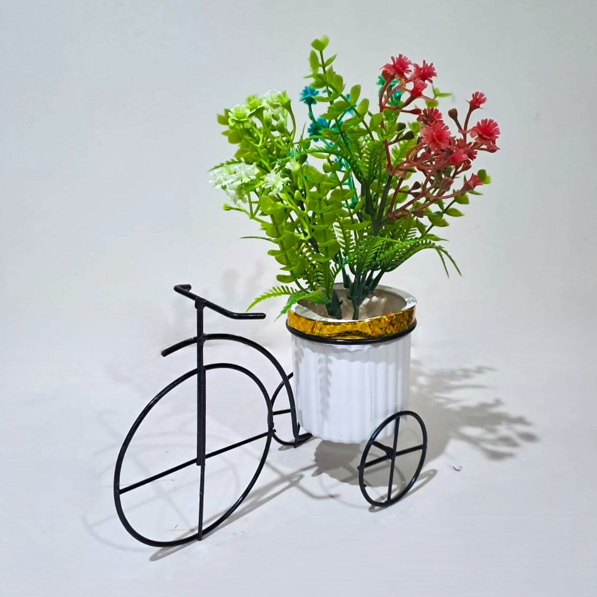 Black Metallic Tricycle with a White Plastic Planter filled with multi colour Gypsophila Flowers